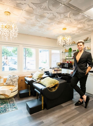 A man stands in a hair salon with stylish decor and seating