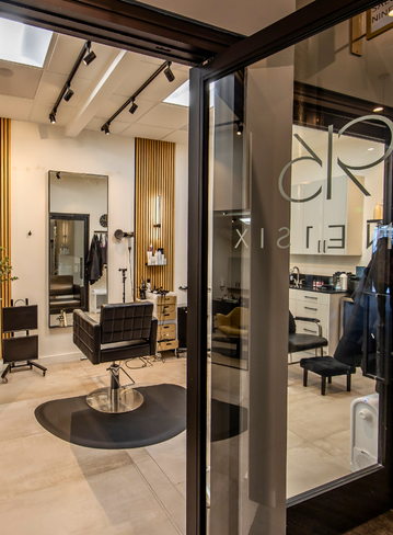 Entrance to a salon with a styling chair, mirror, and modern decor