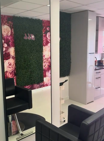 Interior of a salon with floral wallpaper, green wall decor, and styling chairs
