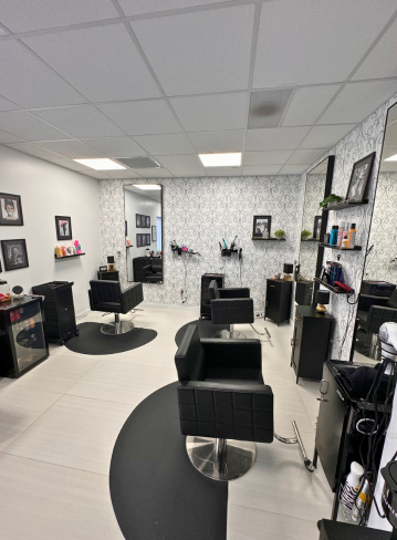 Interior of a hair salon with chairs, mirrors, and decorative wallpaper