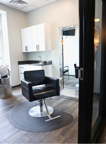 Fully equipped salon suite with hair stylist chair and mirror at Broadway Royal Oak, MI