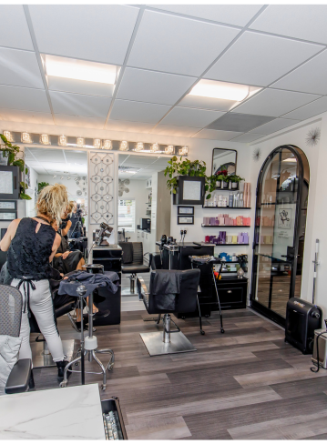 Interior of a hair salon with a stylist working and various styling stations