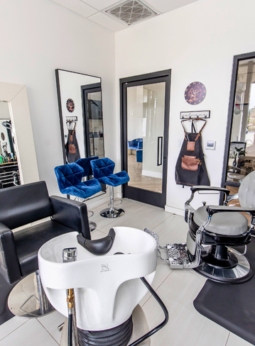 Interior of a hair salon with chairs, mirrors, and a shampoo station