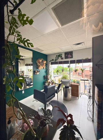 Fully equipped salon suite with hair stylist chair and mirror at Broadway Livonia