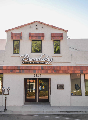Exterior of a two-story building with a tan facade and brown roof tiles
