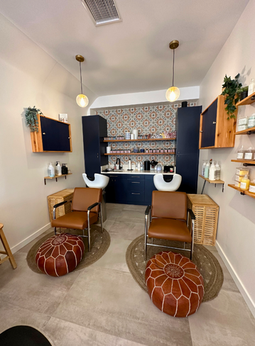 Interior of a salon with two chairs, washbasins, and decorative wall tiles