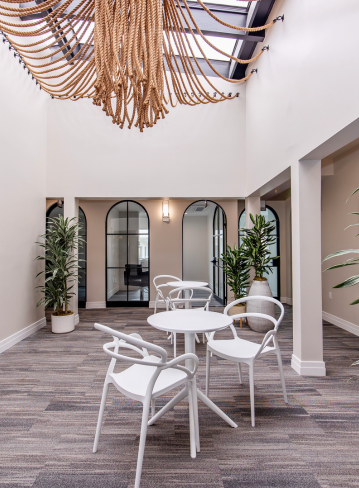 Bright indoor space with a round table, chairs, and decorative plants