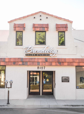Exterior of a building with a sloped roof and large front windows. Entryway is visible