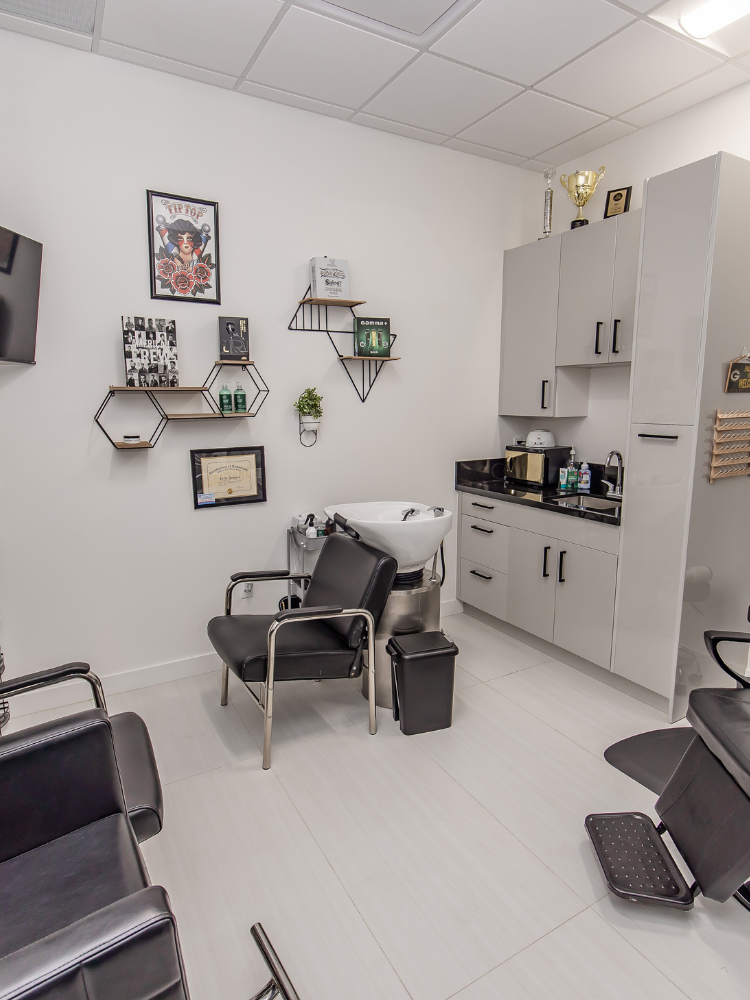 A salon interior with chairs, a wash station, and wall decorations