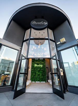 Entrance of a building with double doors, green wall, and light fixture visible inside