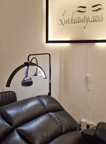 Black leather chair with a lamp and a wall sign above